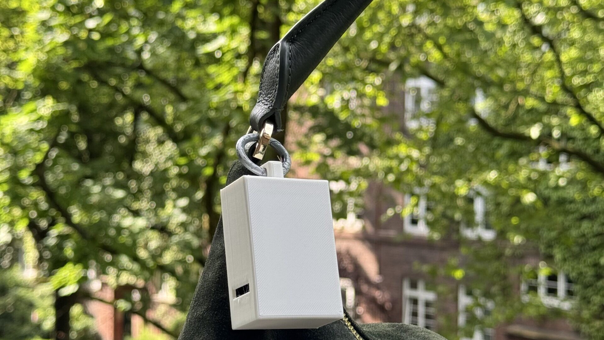 Ein tragbarer Hitzesensor befestigt am Umhängeband einer Handtasche.