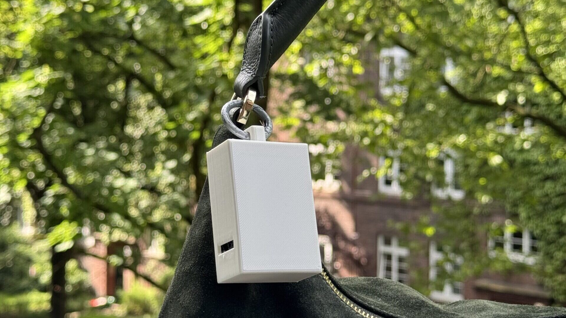 Ein tragbarer Hitzesensor befestigt am Umhängeband einer Handtasche.