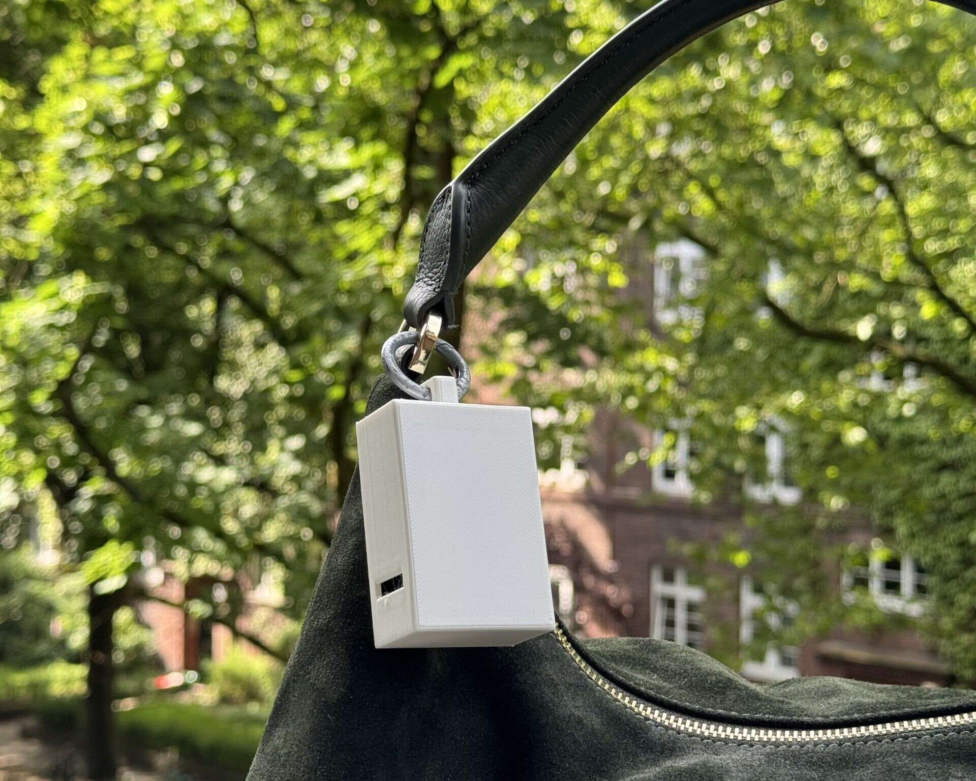 Ein tragbarer Hitzesensor befestigt am Umhängeband einer Handtasche.
